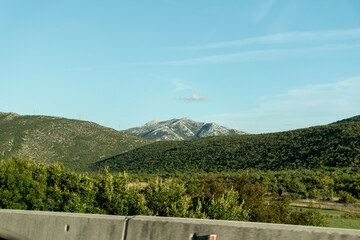 hills in croatia near the highway, beautiful summer mountain landscape, blue sky and clouds