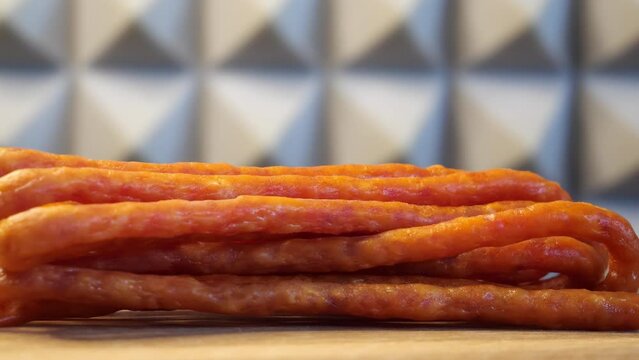 Traditional polish sausages kabanos on a rotating wooden surface. Macro.
