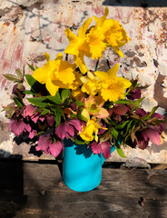 Romantic bouquet with daffodils and hellebores in the sunlight