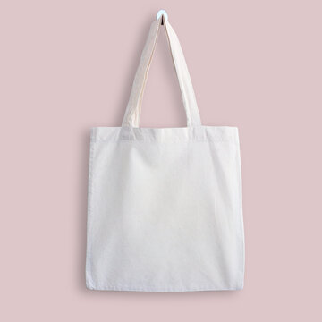 White blank cotton eco tote bag, design mockup. Shopping bag hanging on wall