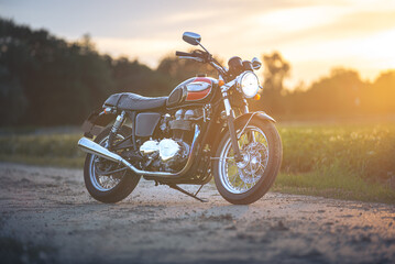 Fototapeta na wymiar Caffeeracer Motorrad auf Feldweg im Sonnenuntergang