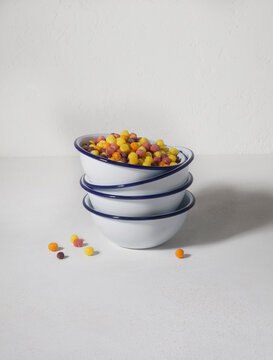 A studio shot of a stack of colorful Cereal bowls on an isolated cement gray background, product image, ecommerce 