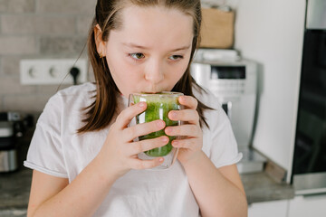 Caucasian girl drinking green juice or smoothie. Healthy lifestyle concept.