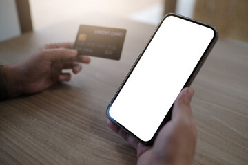 Close up of women's hands holding cell telephone and credit card with blank copy space scree for your advertising text message or promotional content, shoping online.