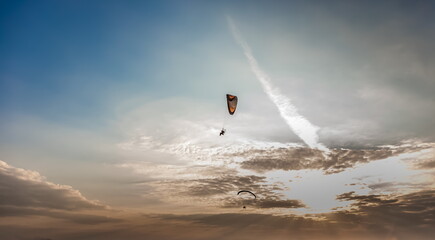 Paraglider on the background of a sunset sky with clouds in summer