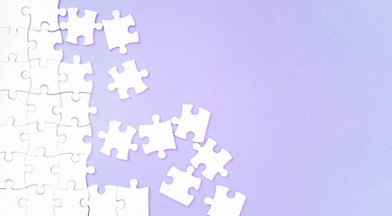 white puzzle pieces on pupple background with copyspace