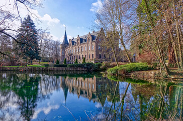 Fototapeta na wymiar Teich mit einem historischen Schloss in einem Park in Paffendorf bei Bergheim