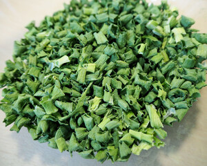 Fototapeta na wymiar a lot of chopped green onions , dried in a dehydrator on a beige background . top view . spice