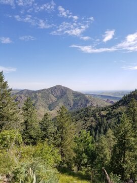 Colorado Mountain Top Side and Forest Lake under Cloudy Blue Sky