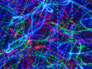 Abstract background multicolor lights with cross filter, crosses, lines and chaotic lights. A twinkling garland, concept of Christmas and winter holidays.