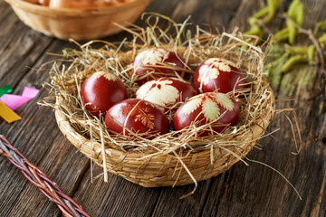 Easter eggs dyed with onion peels in a basket on a rustic table