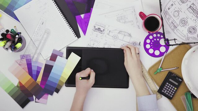 Top view of a creative designer using a graphic tablet while working at his desk