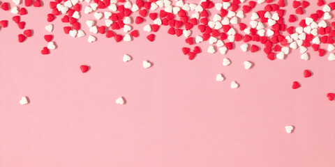 Valentine's Day pattern background. Composition with candy hearts. Symbol heart of sweets on pastel pink background. Flat lay, top view