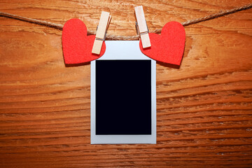 Handmade two red hearts hanging and card on cloth line or rope on wooden background. clipping path....