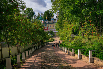 View of the main street of the Holy Dormition Pskov-Pechersk Monastery - the bloody way on a sunny summer day, Pechora, Pskov region, Russia