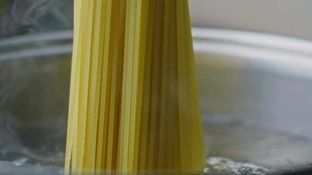 We throw the spaghetti into the water. Overhead shot. Shot with a high-speed camera, slow motion.