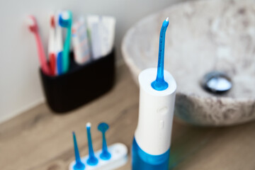 Blue home oral irrigator kit in bathroom, Waterpik for teeth cleaning, portable water flosser for...