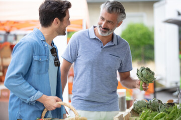 men at fruit counter in supermarket