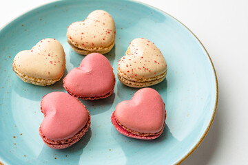 Macarons cakes in a shape of a heart. Small French cakes for Valentines Day. Sweet and colorful french macaroons.