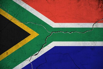An image of the South African Republic flag on a wall with a crack.