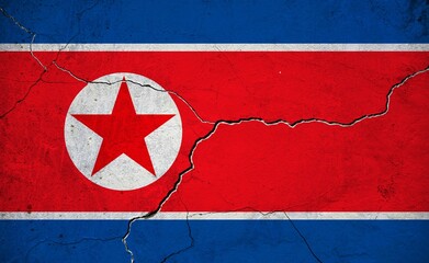 An image of the North Korea flag on a wall with a crack.