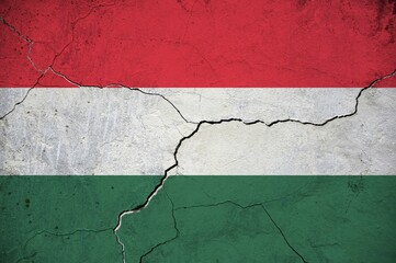 An image of the Hungary flag on a wall with a crack.