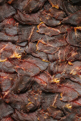 Smoked meat slices in a texture. Looking delicious. Dark shade with some yellow cooked fat.