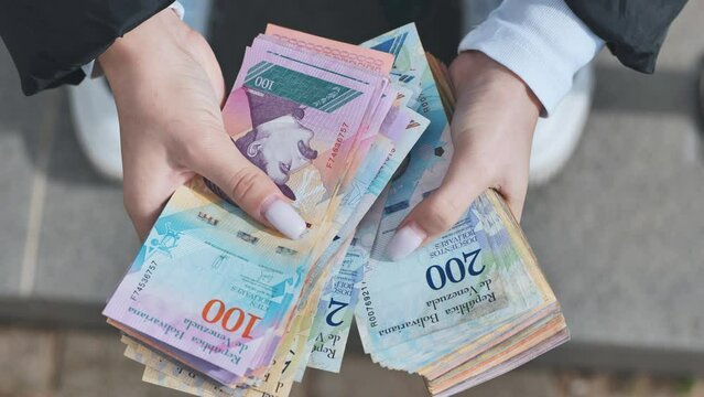 A girl counts old Venezuelan money.