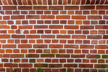 old red brick wall texture background with white concrete glitches and moss on the some bricks
