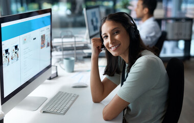 I never miss a call. Portrait of a young woman using a headset and computer in a modern office.