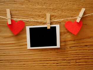 Handmade two red hearts hanging and card on cloth line or rope on wooden background. clipping path....