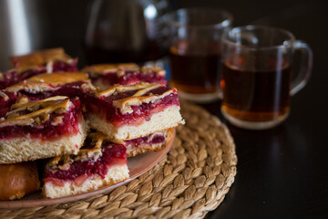 Pieces of a berry pie on a board with tea