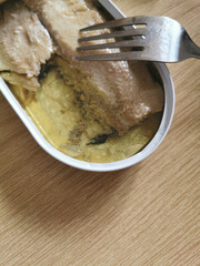 Opened canned mackerel in oil and fork