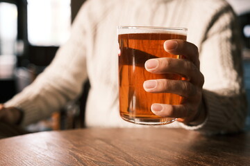 a person holding a glass of beer