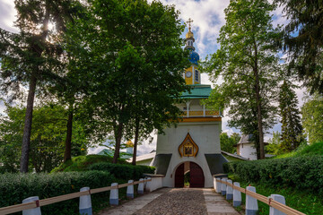 Fototapeta premium View of the main entrance of the Holy Dormition Pskov-Pechersk Monastery Petrovskaya Tower with entrance gates on a sunny summer day, Pechory, Pskov region, Russia