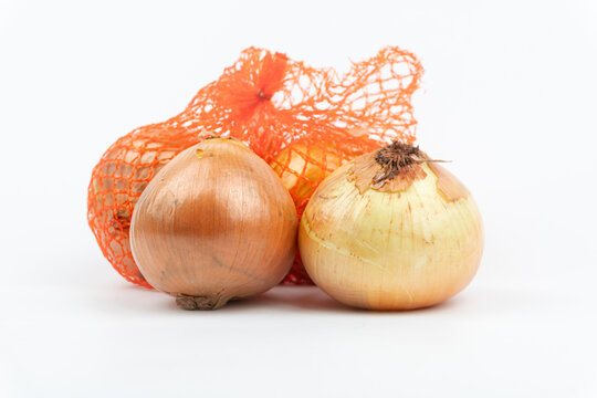 Fresh onions on a white background, net packing, close up on front view
