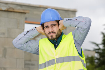 construction worker or engineer covering his ears