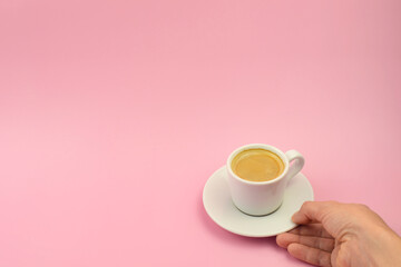 Woman Hand Holding Coffee Cup On Pink Background, top view, copy space. Cup of coffee in hand