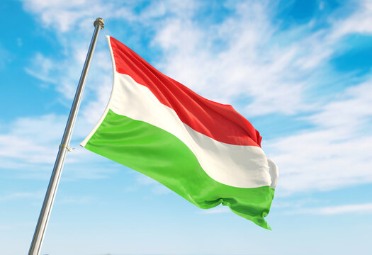 3d rendering Hungary flag waving in the wind on flagpole. Perspective wiev Hungary flag waving a blue cloudy sky