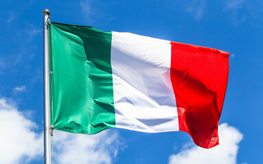 Fototapeta na wymiar Italy national flag on a background of blue sky