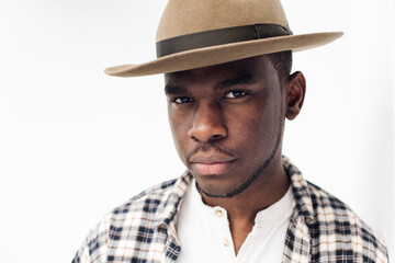 Close up handsome male fashion model with hat by white background staring