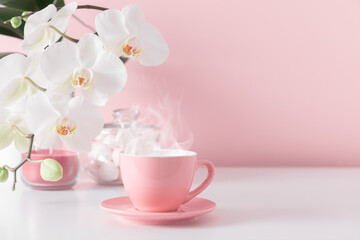 Beautiful flowers composition with white orchid flower, steaming cup coffee or hot drink on pastel pink background. Valentine's day, Happy women's day