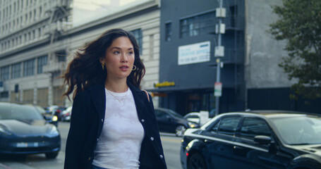 Stylish lady walking city street. Asian businesswoman going meeting on sidewalk.