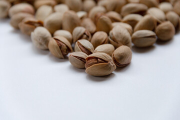 Roasted salted pistachios in a basket, plate on a white background