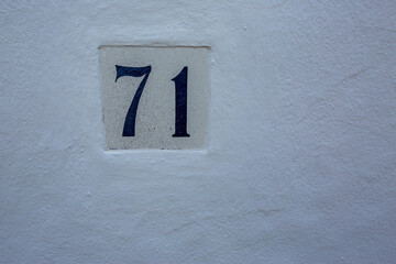 Seventy one. 71. Ceramic tile. Street number or house number. Travel photograph from a street in Andalusia, Spain
