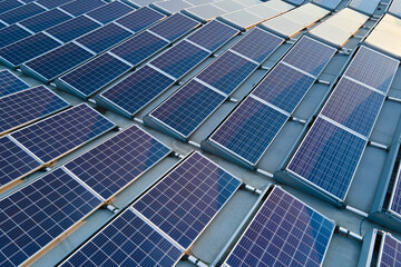 Aerial view building roof with rows of blue solar photovoltaic panels for producing clean ecological electric energy. Renewable electricity with zero emission concept