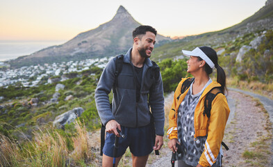 Hiking my favourite trail with the person I adore. Shot of a young couple hiking at sunset on a...