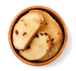 Dried bread with raisins in a wooden plate on a white. Top view