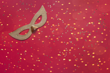 Carnival mask and golden glitter confetti. Top view, Close up on blue background