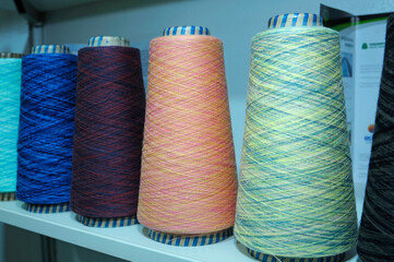 Colorful knitted thread spools put on a shelf at a shop